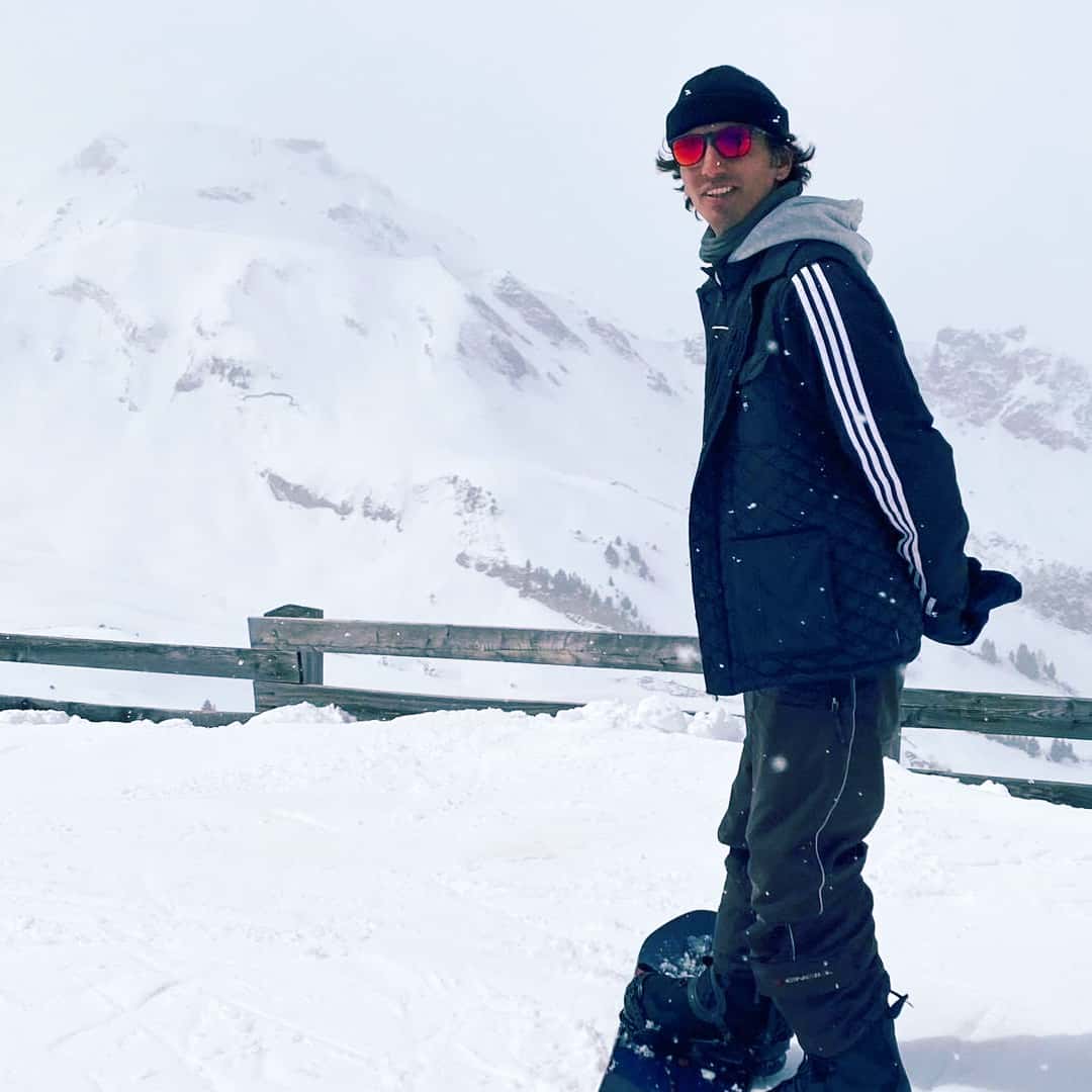 Arun Roy standing on a snowboard in Haute-Savoie in the French Alps