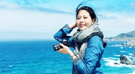 female-enjoying-great-view-of-sea-with-camera-2023-11-27-04-50-14-utc